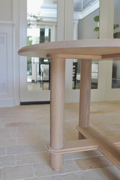 A round white oak entry table with crossbraces.