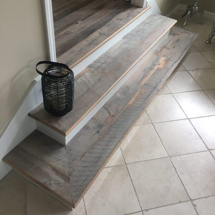 A lantern sits on two steps with barnwood flooring finished with a hardwax oil wood finish.