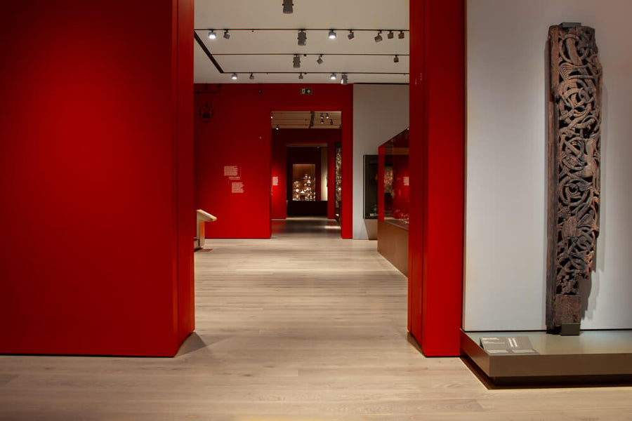 An area of the Norwegian National Museum with a carved wood sculpture, red painted walls, and a light hardwood floor finished with Oil Plus 2C.