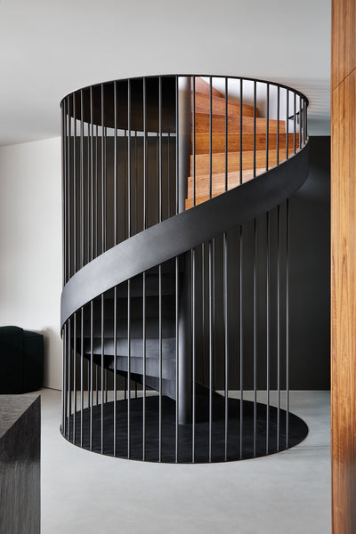 A spiral staircase encased in black metal railing.