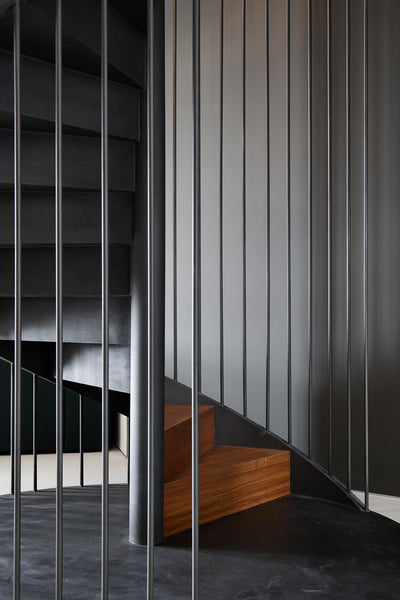 Metal railing on a spiral staircase made from European oak. 