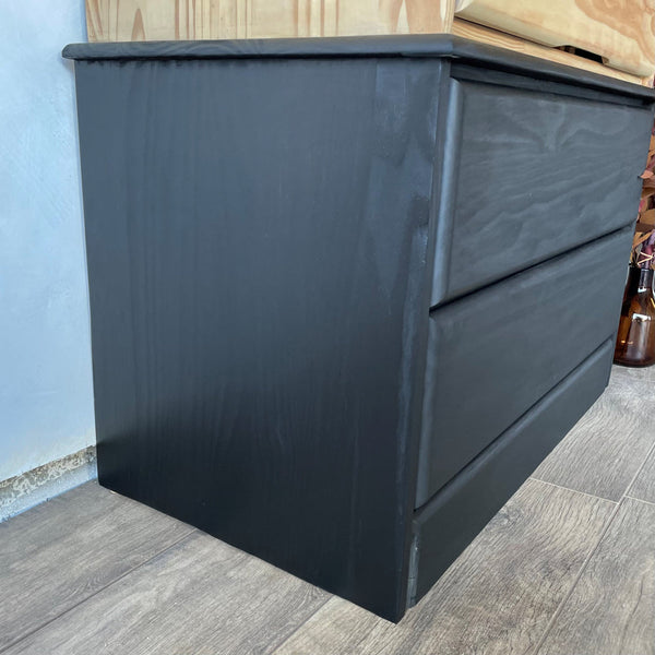 The lower drawers on a pine armoire finished in an opaque black look using Rubio Monocoat Precolor Easy Intense Black and Oil Plus 2C Pure.