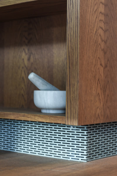 A close up of a storage nook with a mortar and pestle sitting inside.