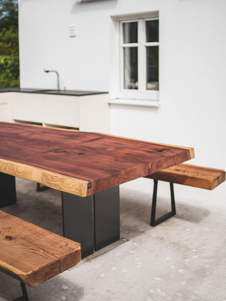 An exterior dining table made from redwood and finished with Rubio Monocoat Hybrid Wood Protector.