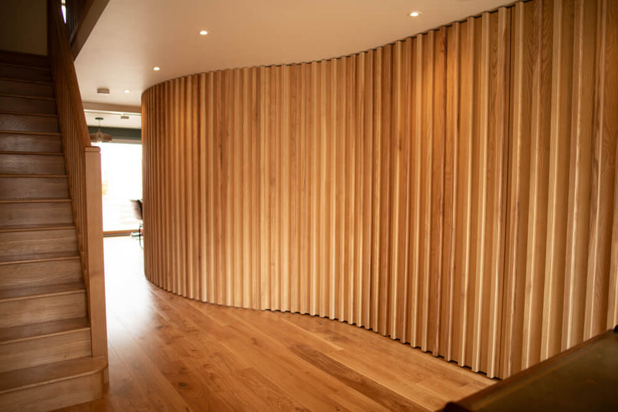 A curved ash slatted wall finished with Rubio Monocoat hardwax oil wood finish.