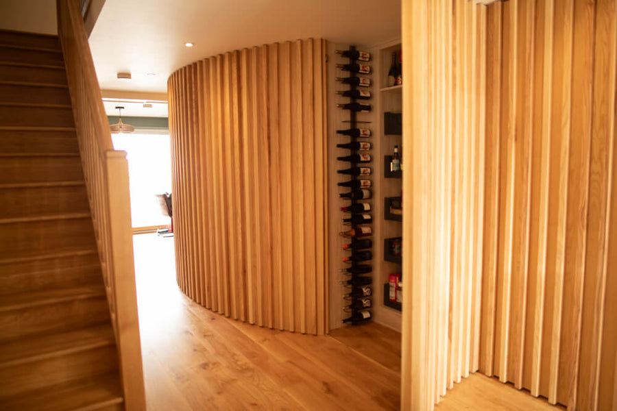 A curve wall made from ash veneer that boasts hidden storage.