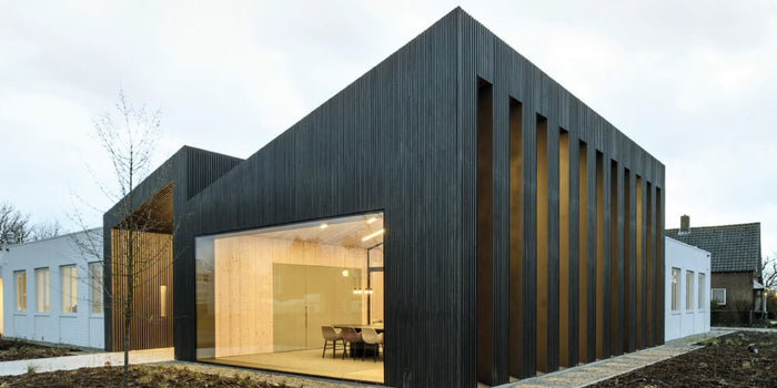 Wood exterior siding on a modern office building, finishing in black wood finish.