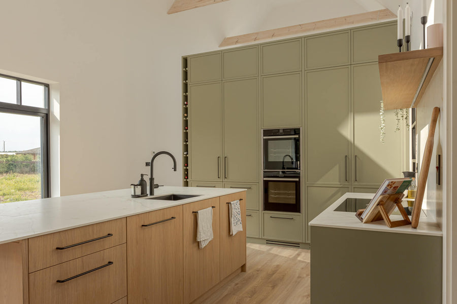 Tall kitchen cabinetry painted a sage green color. The light colored oak island was finished with Rubio Monocoat Oil Plus 2C "Smoke".