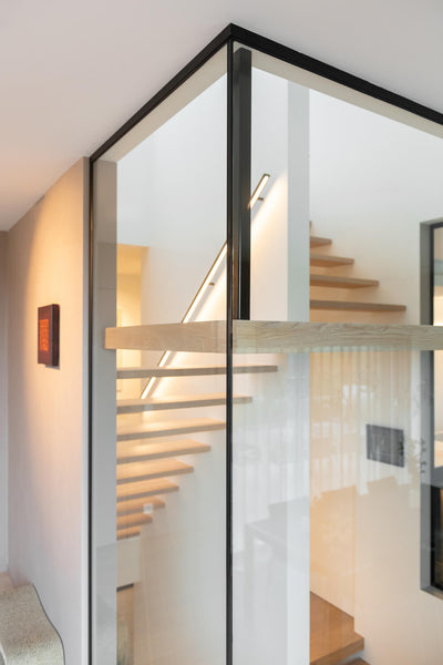 A staircase with glass wall surrounding it made from European oak wood.