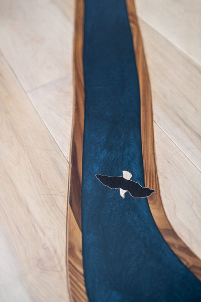 Epoxy river in hardwood flooring with a small wooden eagle inlaid.