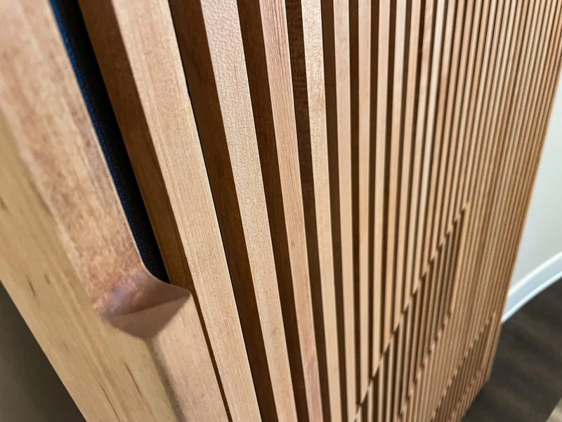 The integrated handle of a curved slatted maple door finished with a hardwax oil finish.
