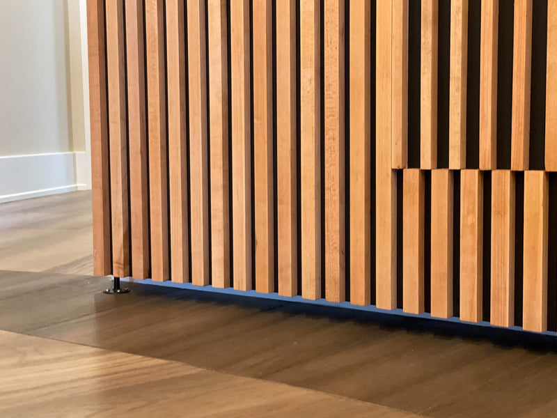 A detailed view of the hardware used on a curved slatted maple wood door.