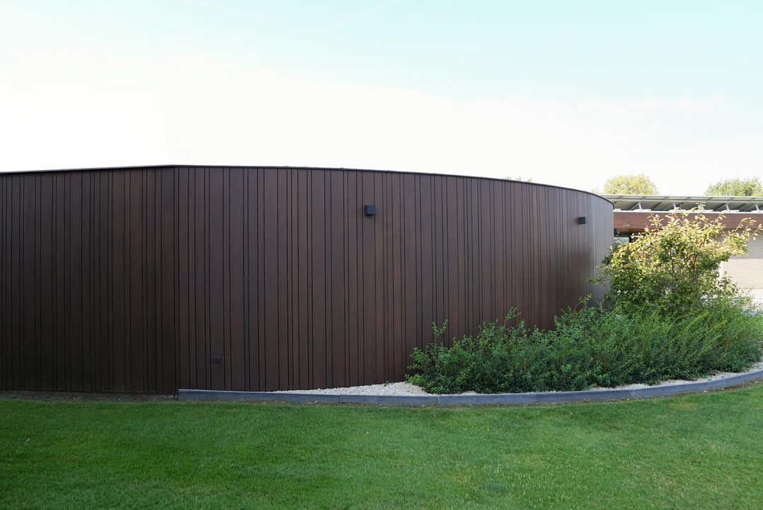 Vertical privacy fencing made from thermo ayous wood and finished with DuroGrit in the color Rocky Umber.