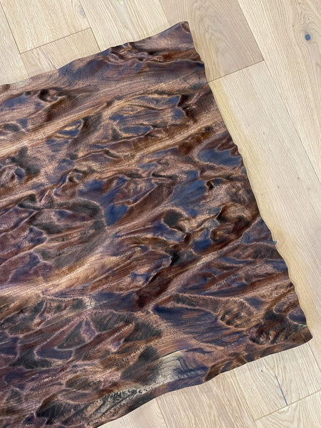 Part of a topographic map made from walnut that depicts the Canadian Rocky Mountains.
