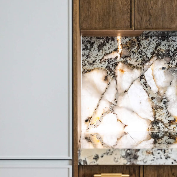 A minimalist kitchen featuring Patagonian stone countertops and backsplash.