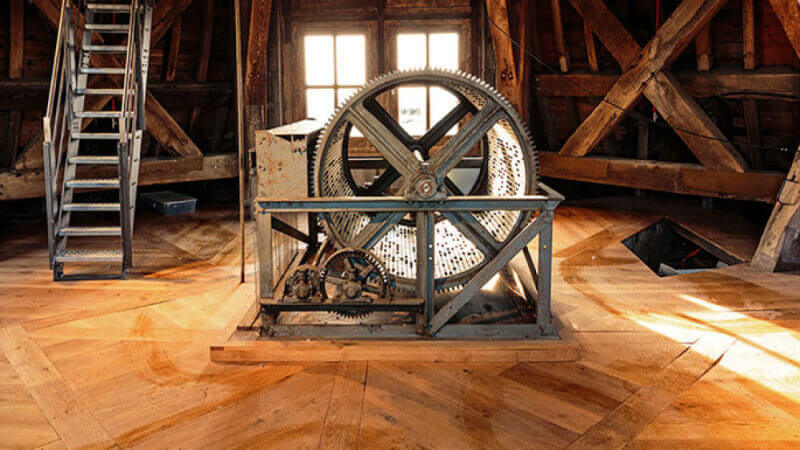 The music machine in the top of the cathedral spire, surrounded by wood flooring.