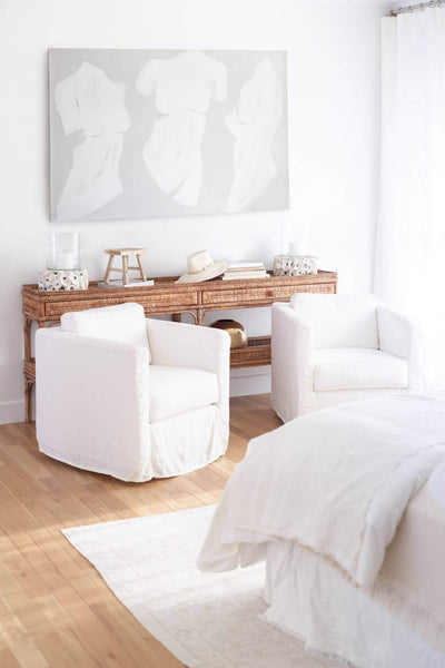 Guest bedroom with natural hardwood flooring and white decor