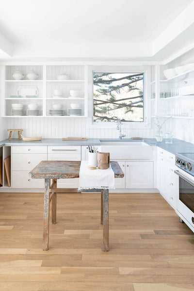 Light and airy kitchen with white cabinetry and natural hardwood flooring