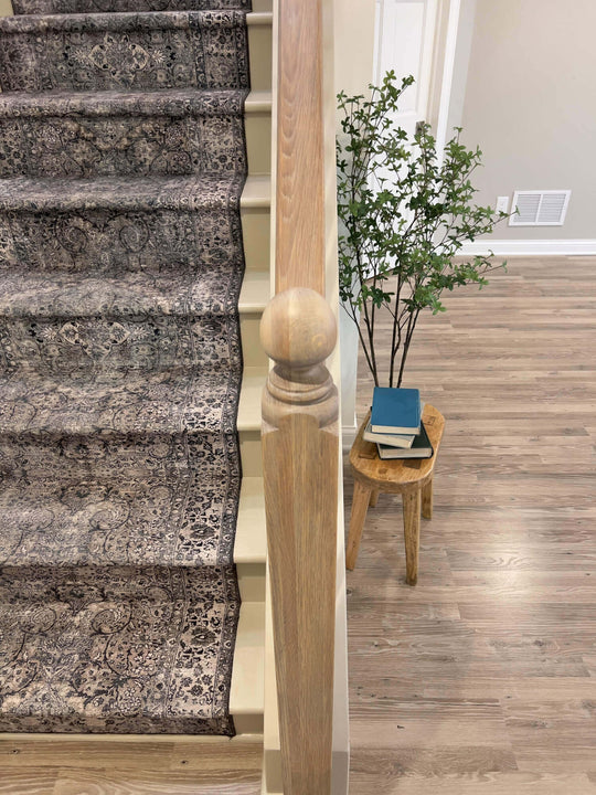 White oak stair railing post with a rounded finial finished with a water-based wood stain and hardwax oil.