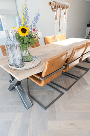 Dining room with a hardwood floor in herringbone pattern that is finished with a strong floor finish.