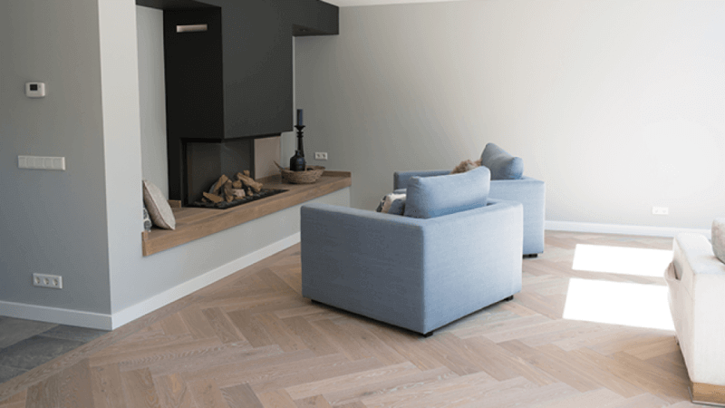 Herringbone hardwood flooring in a living area with a durable floor finish applied.