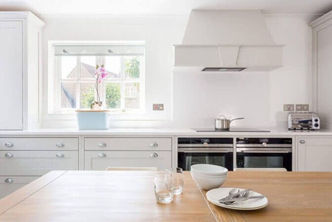 White shaker kitchen with natural wood table.