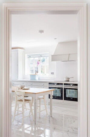 Doorway into a white shaker kitchen.