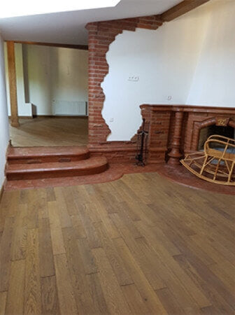 Hardwood and brick threshold between flooring and stairs.