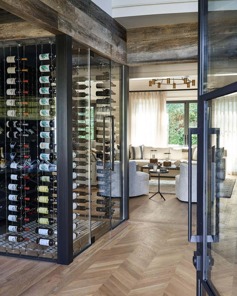Wine cellar in custom home with white oak chevron wood flooring.