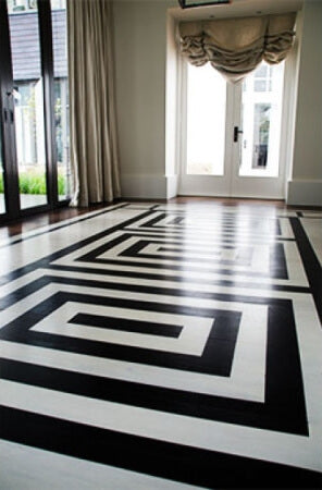 A black and white patterned floor with french doors leading outside.