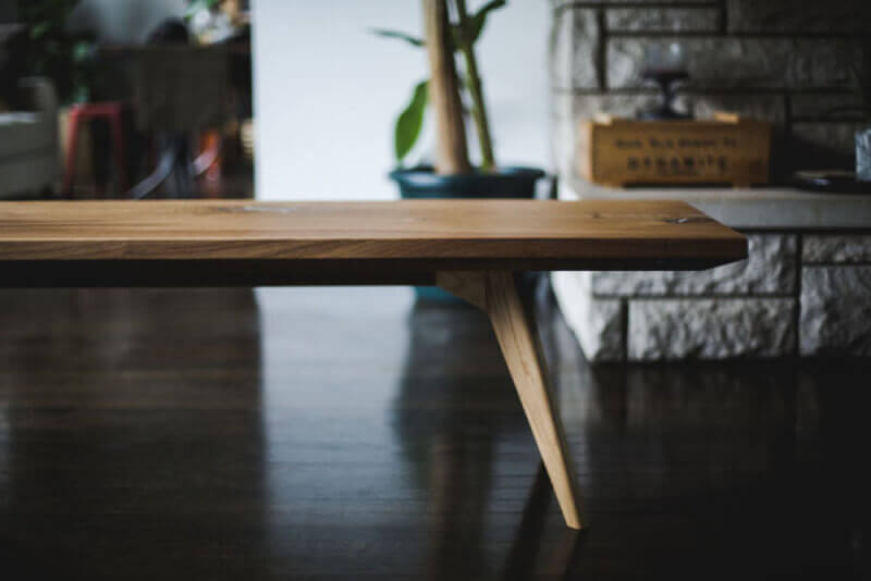 Side profile of a modern oak hardwood coffee table that has a matte finish on it.