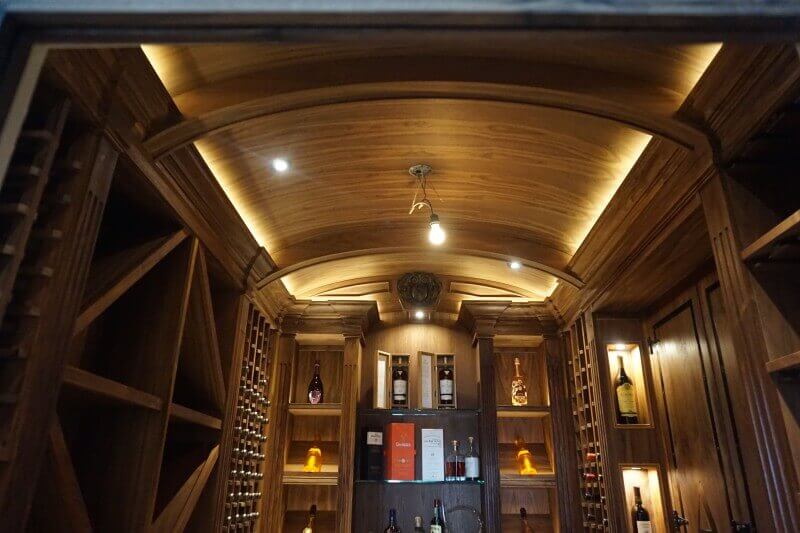 Walnut liquor room with accent lighting.