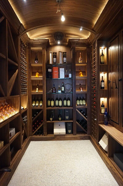 Walk-in walnut liquor room with accent lighting inside.