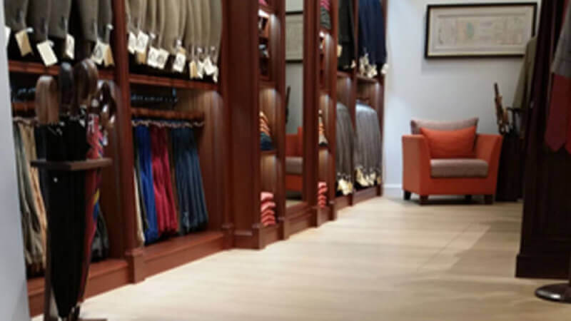A clothing store with natural colored hardwood flooring throughout.