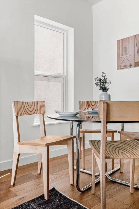 Wood chairs at a glass dining table.