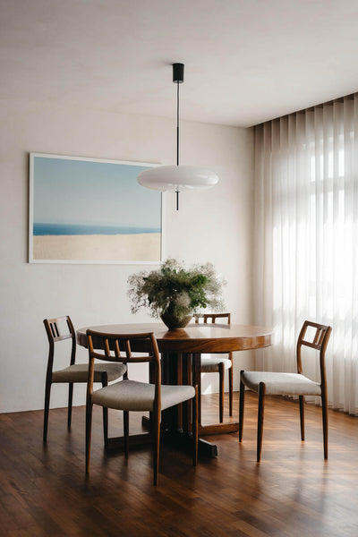 A wood dining table and four chairs sit in a modern dining area.