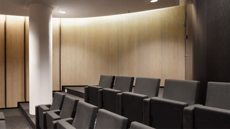 Seating and a wall of wooden acoustical panels that are treated with Rubio Monocoat hardwax oil wood finish.