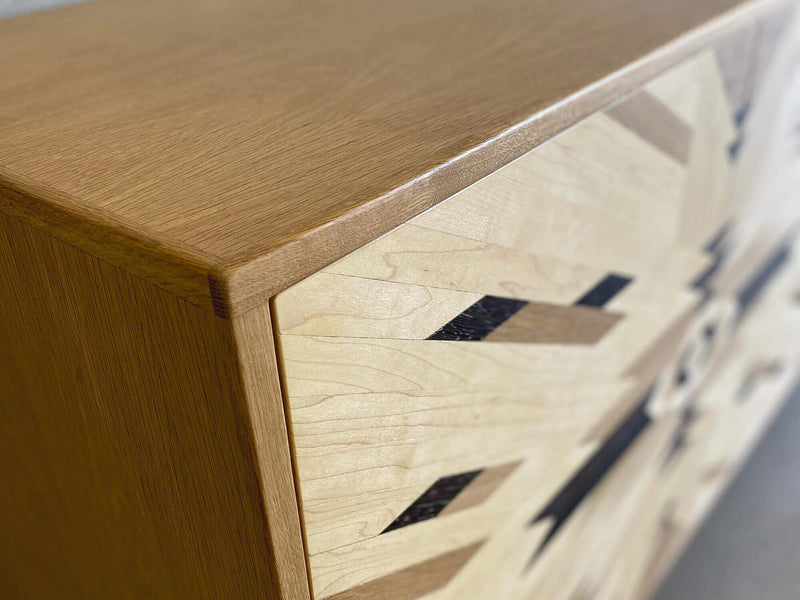 Corner details of a custom credenza with tribal pattern cabinet doors, made from solid maple, white oak, and wenge.