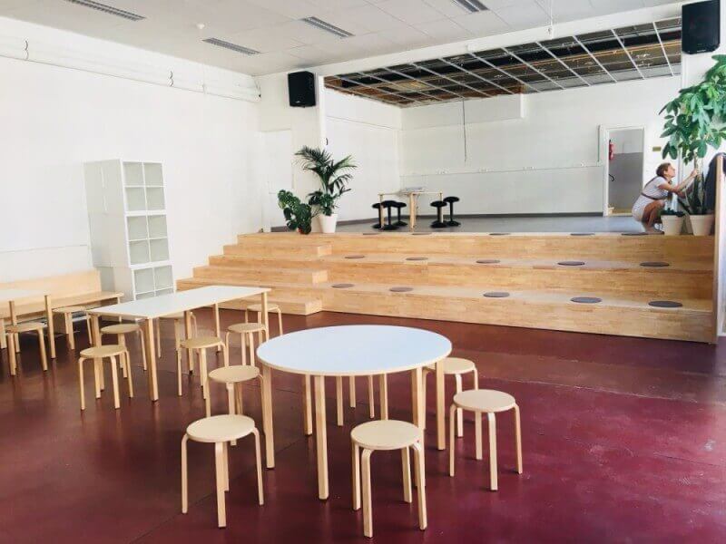 Tables and chairs in a school with a toy-friendly environmental wood finish on them.