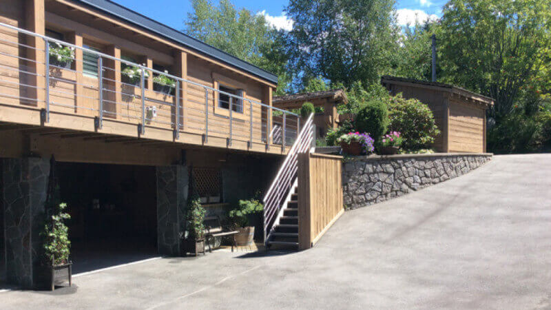 A driveway entering into a recently renovated wooden chalet.