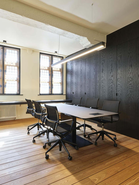 Matte wood floors in an office with large black wood wall cabinetry.