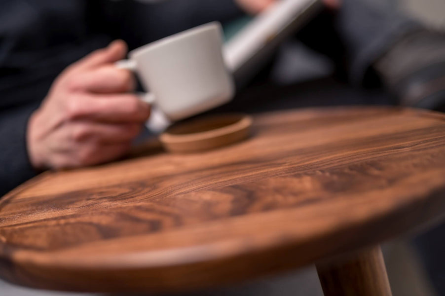 Walnut coffee tray table with a man picking up a coffee cup.