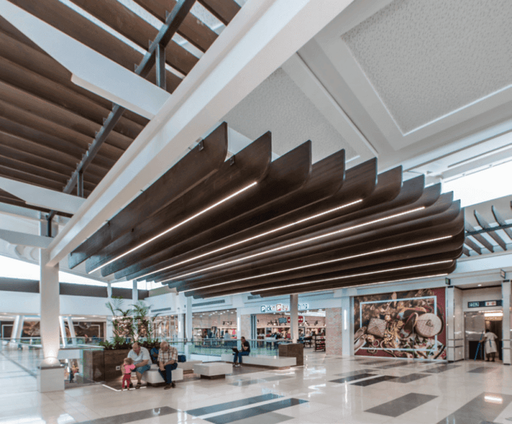 Wooden planks hung from the ceiling in a mall for cosmetic and acoustic reasons, finished with Rubio Monocoat Oil Plus 2C matte finished hardwax oil wood finish.