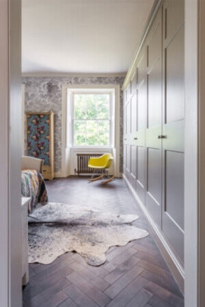 A beautiful matte finished herringbone hardwood floor in a bedroom.