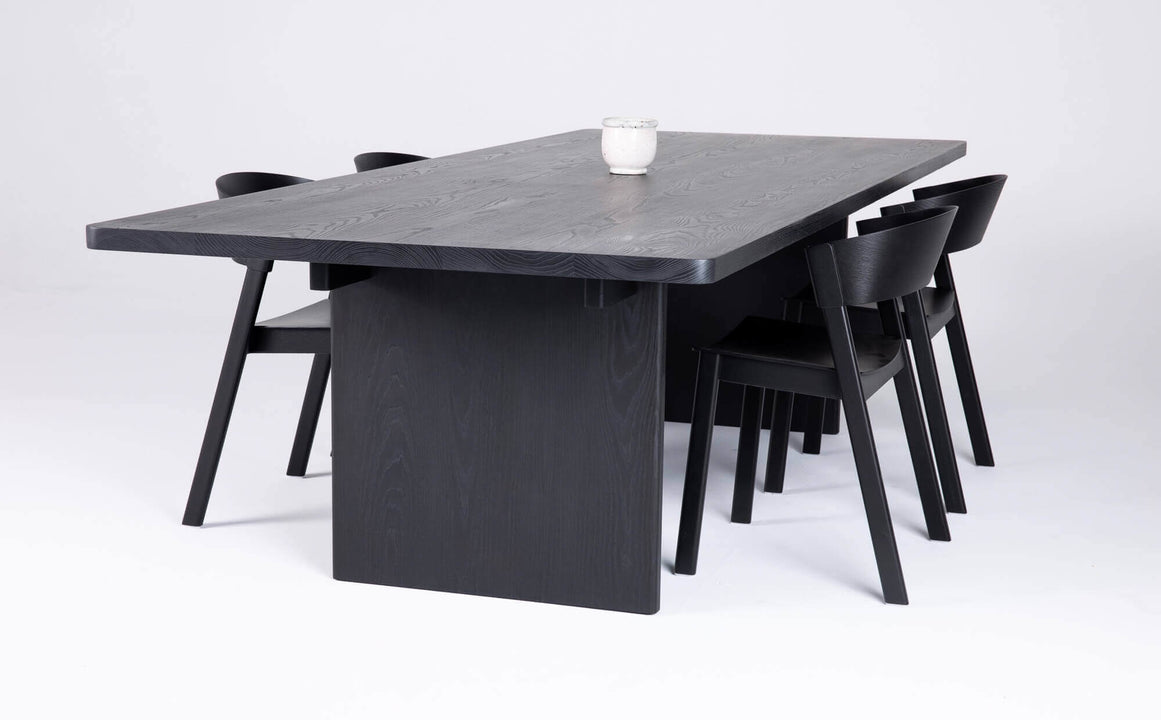 Side view of a black stained ash dining table