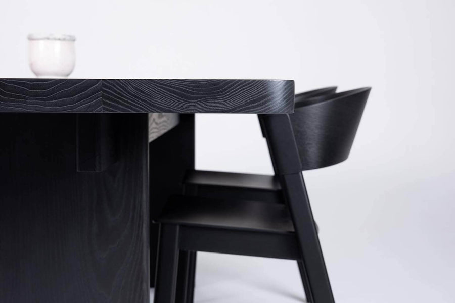 Wood grain details of ash wood midcentury modern dining table and chair with black stain and natural oil finish
