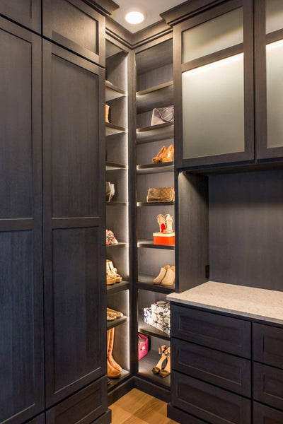 Corner of a large closet with built in shoe shelves.