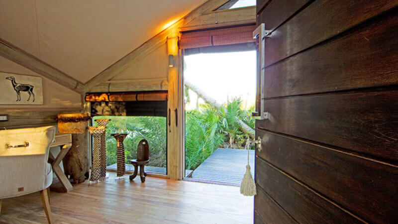 The room of a luxury safari lodge with wooden wall panels.